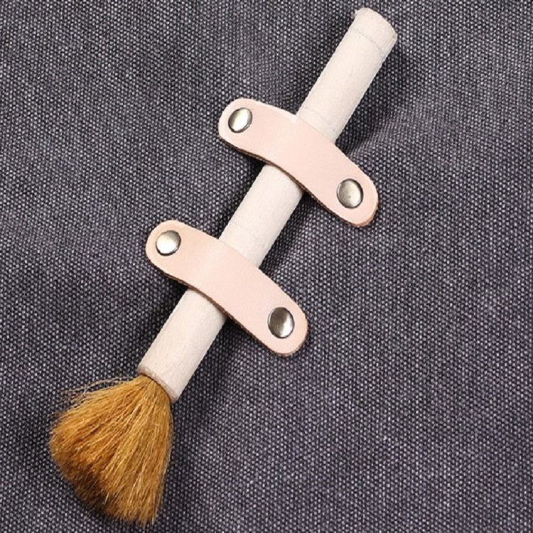 Thick canvas apron strap detail with tan leather cross-laced fasteners and brush holder