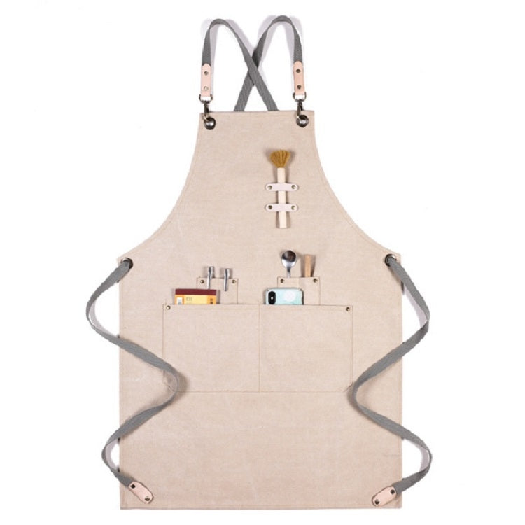 Beige thick canvas apron with X-back straps, front organizer pockets, and hanging loops