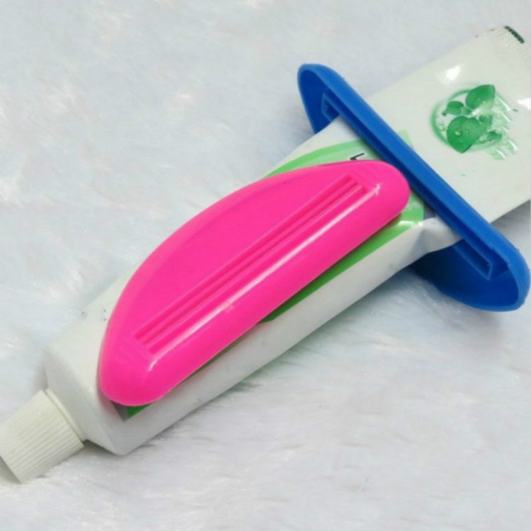 Pink and blue toothpaste squeeze tools with ribbed pressing channels for tubes
