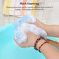 Blue soft mesh shower brush with wooden handle lathering on skin, hanging loop visible.