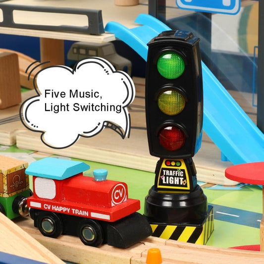 Toy traffic light with lit green, yellow, and red signals on a blue track set