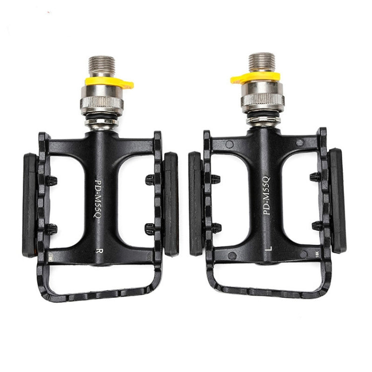 Pair of black quick-release bike pedals with yellow lock lever and silver axles