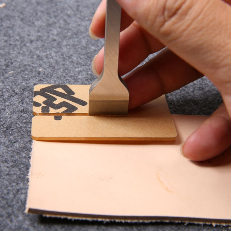 Hand using metal leather stitch punch tool to mark stitches on leather