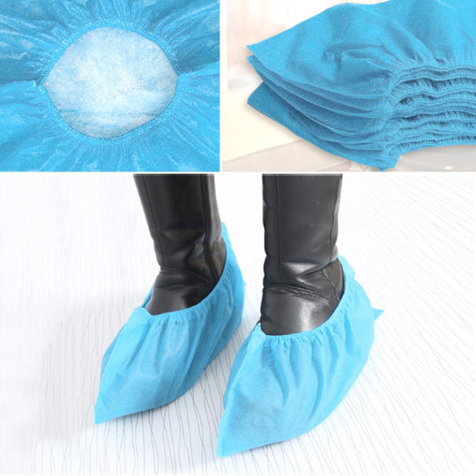 Blue disposable non-woven shoe cover with elastic cuff opening, close-up