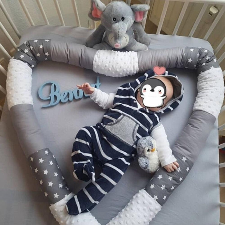 Cylindrical crib bumper with gray star pattern and soft padded side panels