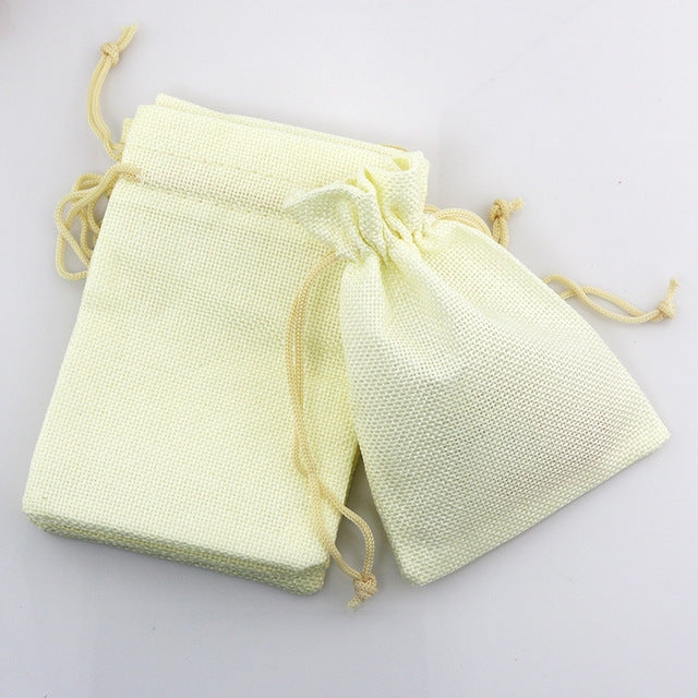 Light yellow linen drawstring gift bag set, two pouches with tied cords.