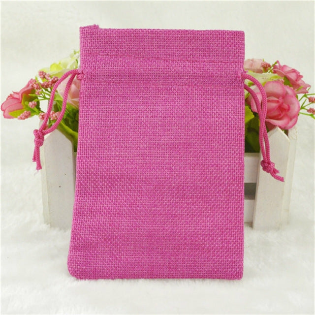 Pink linen drawstring gift bag with drawstring closure and gathered top.