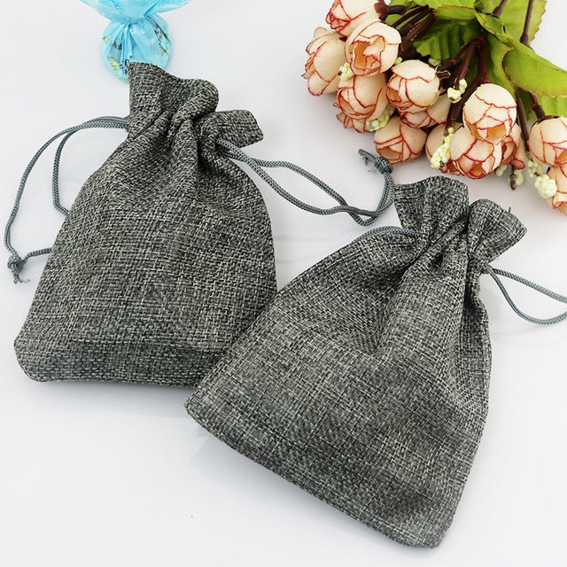 Gray linen drawstring gift bags, two pouches with braided rope ties.