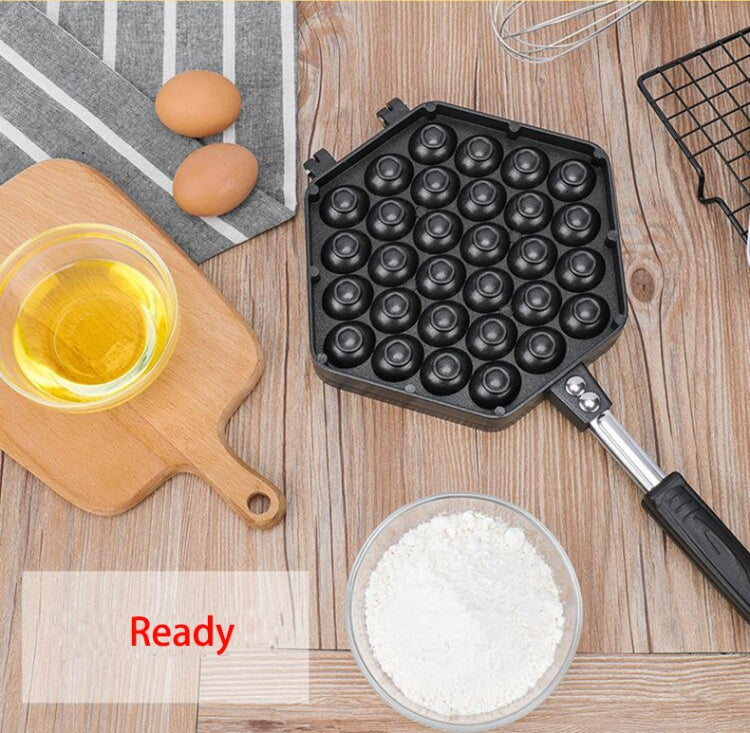 Non-stick egg puff bakeware mold with round cavity pattern and handle on countertop