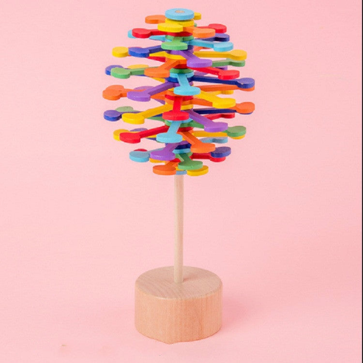 Multi-colored stacked disc lollipop decompression toy on a round wooden base