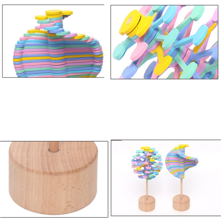 Rainbow striped spin lollipop decompression toy on round wooden base, top view detail