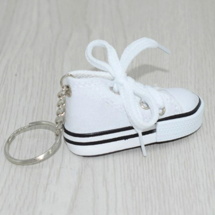 White mini canvas sneaker keychain with white laces and attached metal key ring