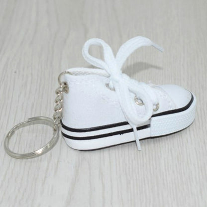 White mini canvas sneaker keychain with white laces and attached metal key ring