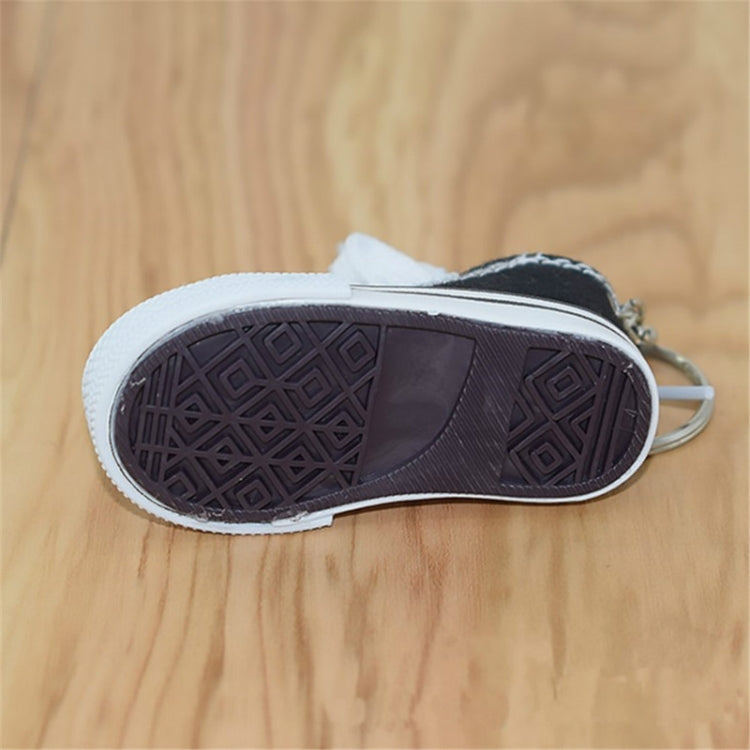 Black mini canvas sneaker keychain with textured sole and metal key ring