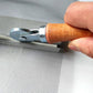 Window spline roller tool held by hand, metal wheel rolling on wire screen mesh