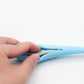 Blue silicone dolphin cat teeth cleaning toy, fingers pressing side for grip