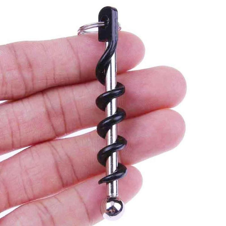 Corkscrew key ring held by hand, black spiral and chrome ball tip