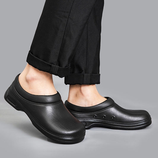 Black slip-on chef shoes worn with dark pants; low cut upper and cushioned sole