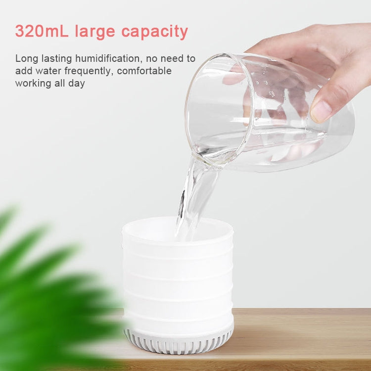 Light gray mini humidifier with water being poured into the top opening, compact design.