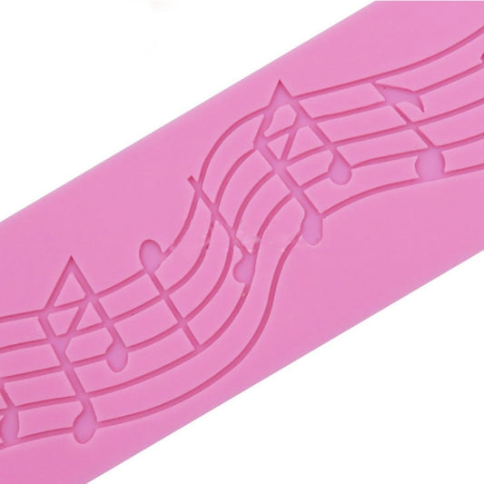 Close-up of pink silicone music-note fondant mold with embossed curved staff lines