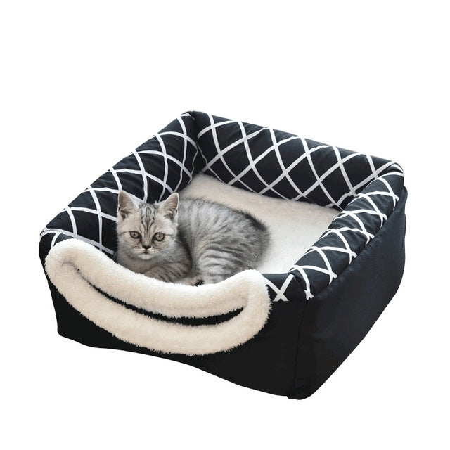 Black geometric cat bed with round plush entrance; gray cat resting inside