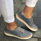 Blue slip-on sneakers with perforated upper, striped strap detail, and cream-colored sole