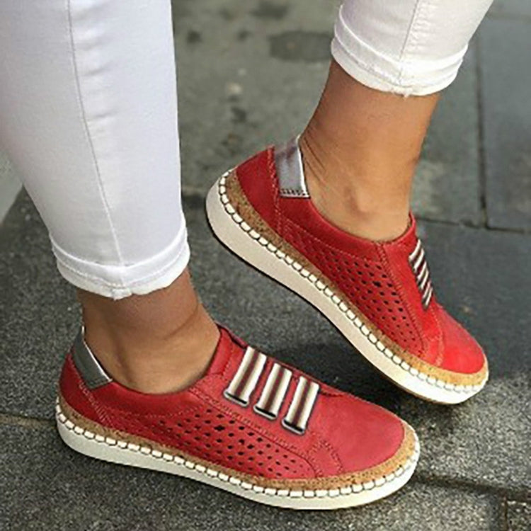 Red perforated slip-on sneakers with striped metal accent and cushioned collar