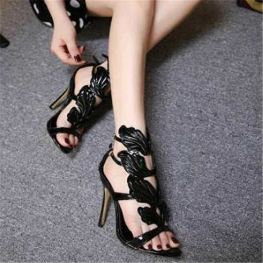 Black metal wing high heel sandals with peep toe, ankle strap, and sculpted wing detailing