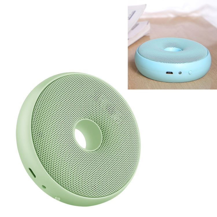 Green portable air purifier with circular grille and central ring opening.