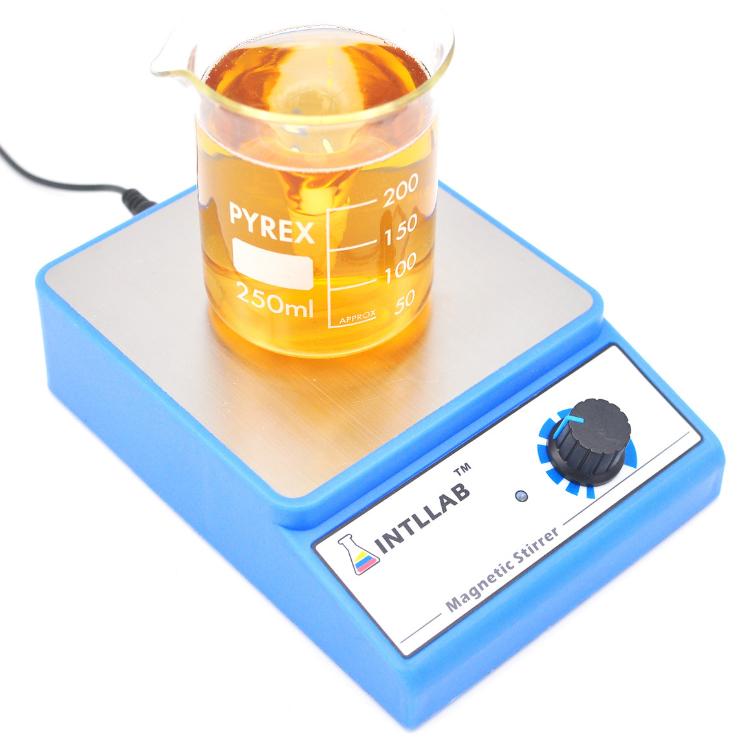 Blue magnetic stirrer with glass beaker of amber liquid and speed knob