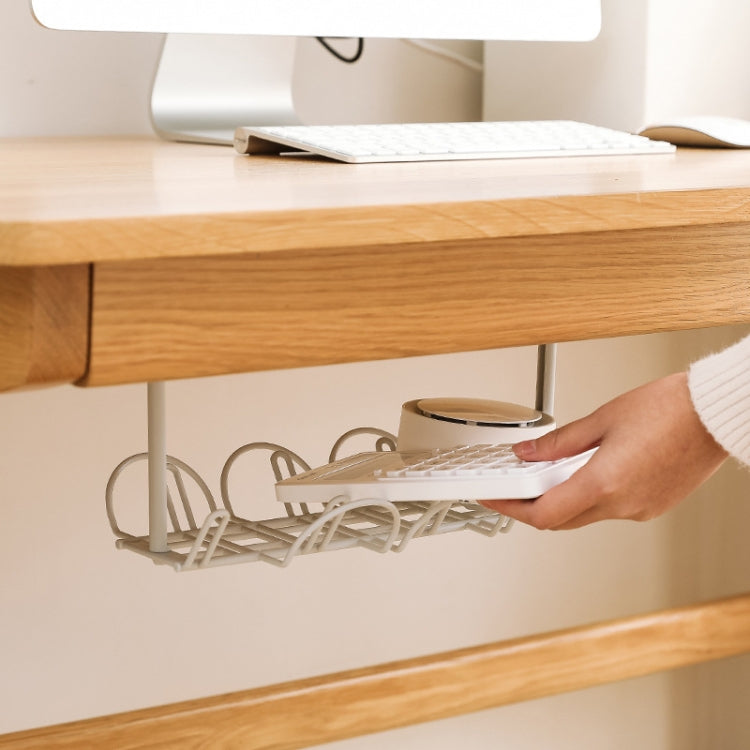 White under-table cable rack with hanging shelf, holding a power adapter for storage