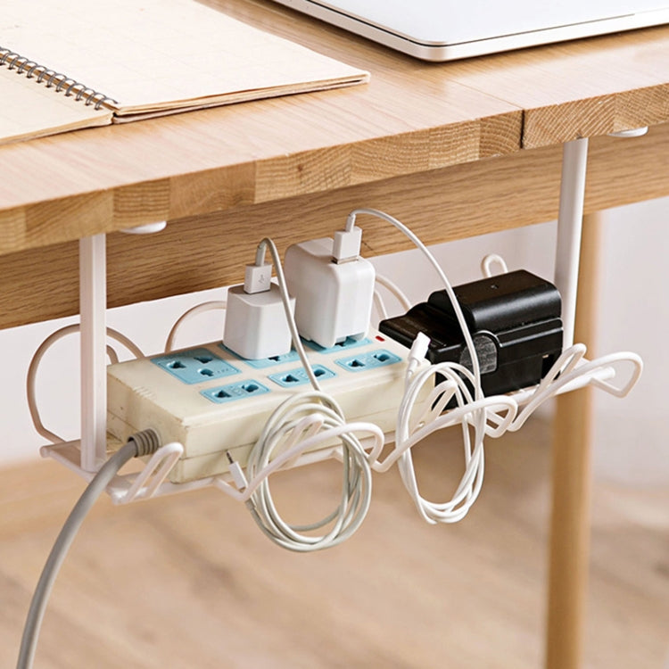 White under-desk cable rack holding power strip, adapters, and cable loops