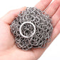 Close-up of stainless steel scrubber net ball texture with circular ring loop