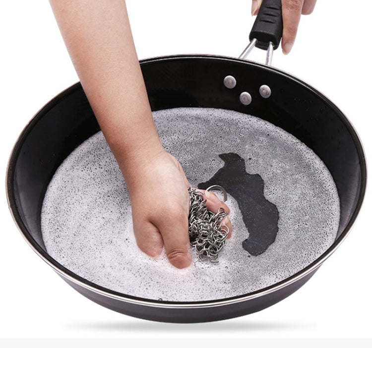 Hand using square stainless steel scrubber net in a pan with soapy water