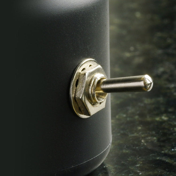 Black night light base with metal charging switch knob, close-up detail