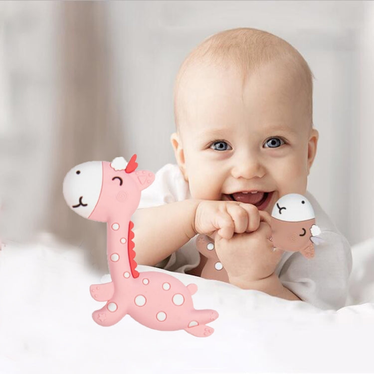 Pink fawn-shaped silicone teether with doe-face ends, in a baby's hand