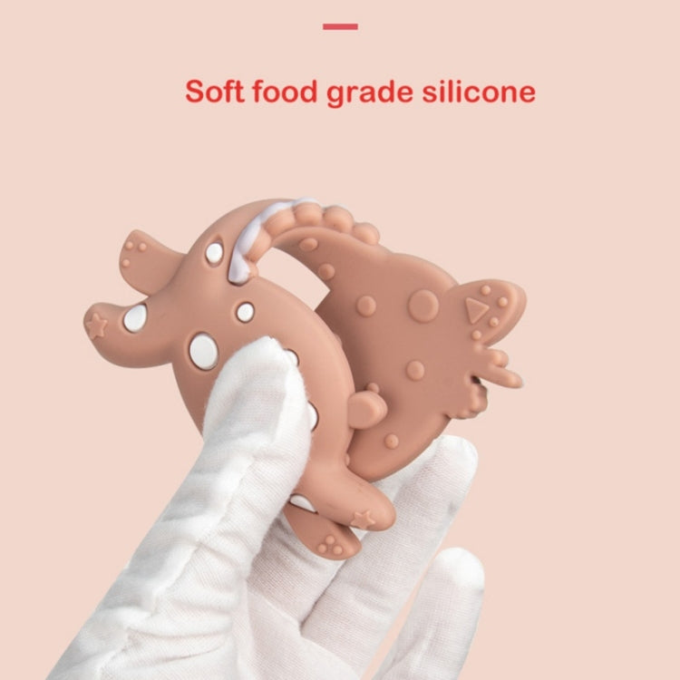 Brown fawn-shaped silicone teether with white gnawing detail, shown being held