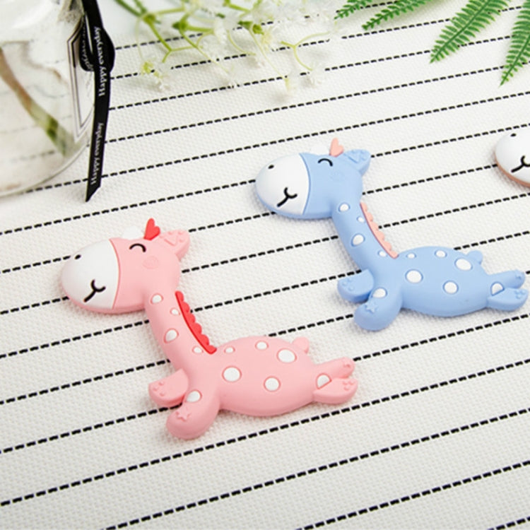 Pink and blue fawn-shaped silicone teethers with doe-face heads on a lined sheet