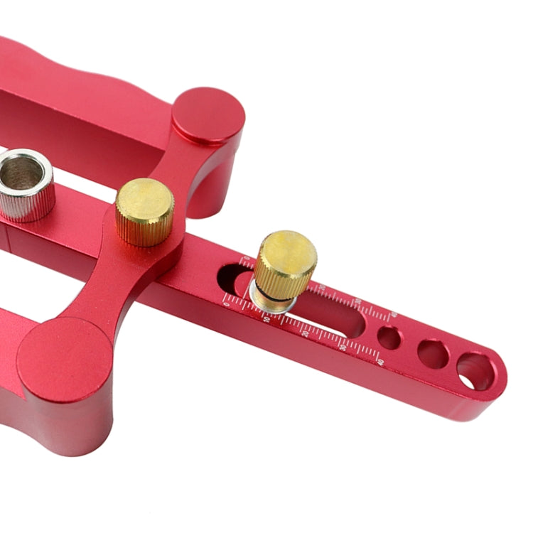 Red vertical triple-hole dowel locator with ruler scale and gold guide posts
