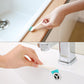Cleaning brush with teal bristles used along a faucet base and sink edge