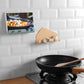 Wall-mounted phone holder with hook arms holding a cable on a tiled wall