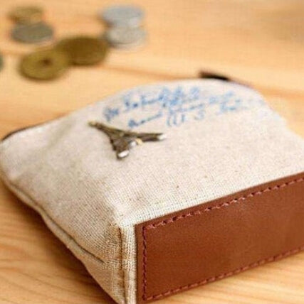 Gray canvas coin pouch with zipper tab and brown leather trim, vintage script print