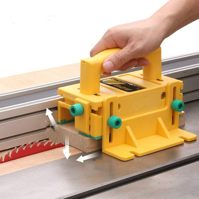 Yellow push handle safety guard with teal knobs on a table saw fence