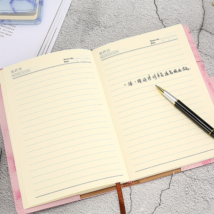 A5 pink notebook opened to ruled pages with pen