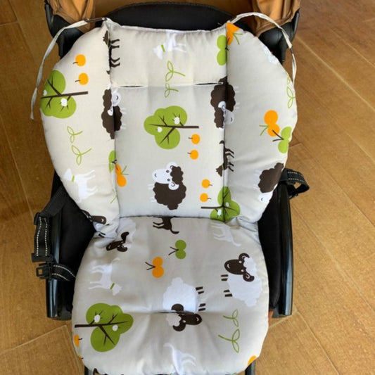 Quilted white stroller cushion with green and brown animal print, padded seat and back