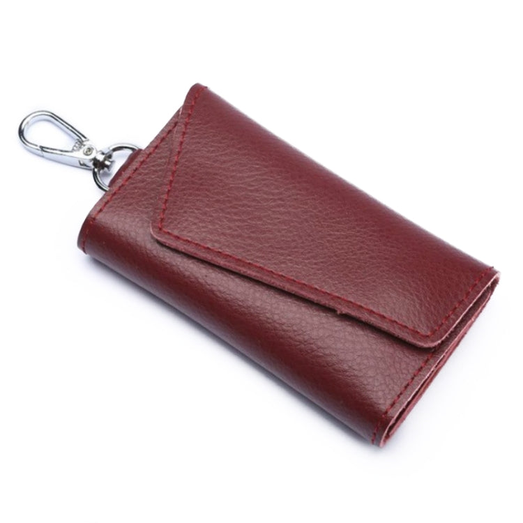 Maroon leather keychain pouch with stitched snap flap and metal keyring, litchi texture.