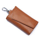 Tan leather keychain pouch with stitched snap flap and metal keyring, litchi texture.