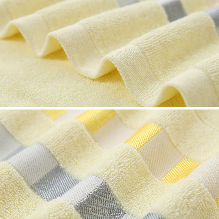 Cotton bath towel fabric close-up with off-white terry and yellow check trim border