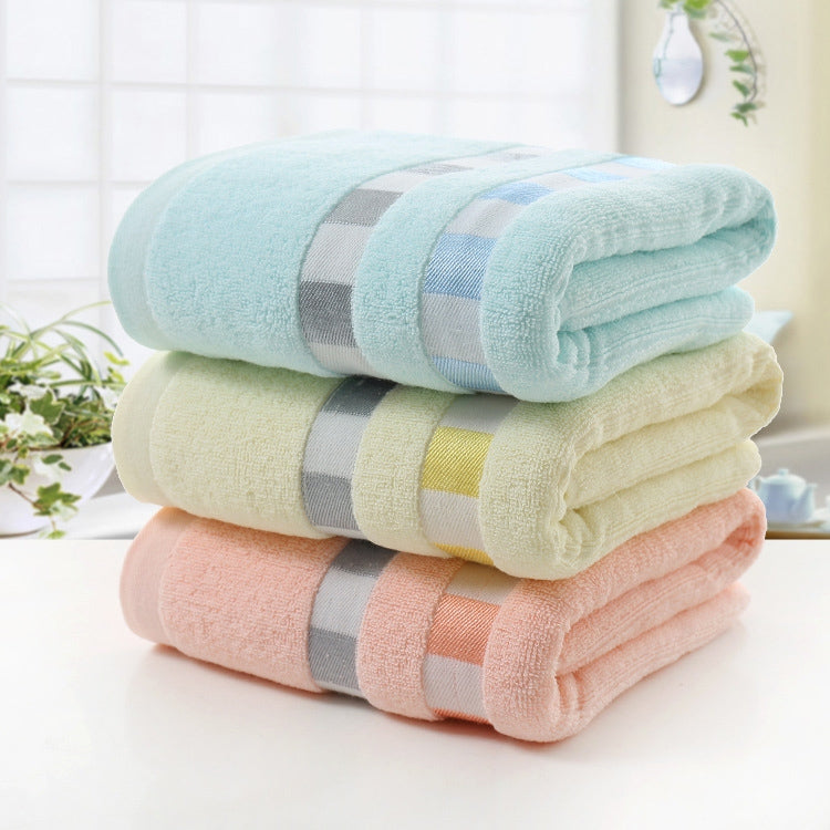 Cotton bath towel stack in light blue, off-white, and light pink with gray stripe bands