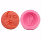 Two round silicone face molds: orange and pink with embossed face profiles.